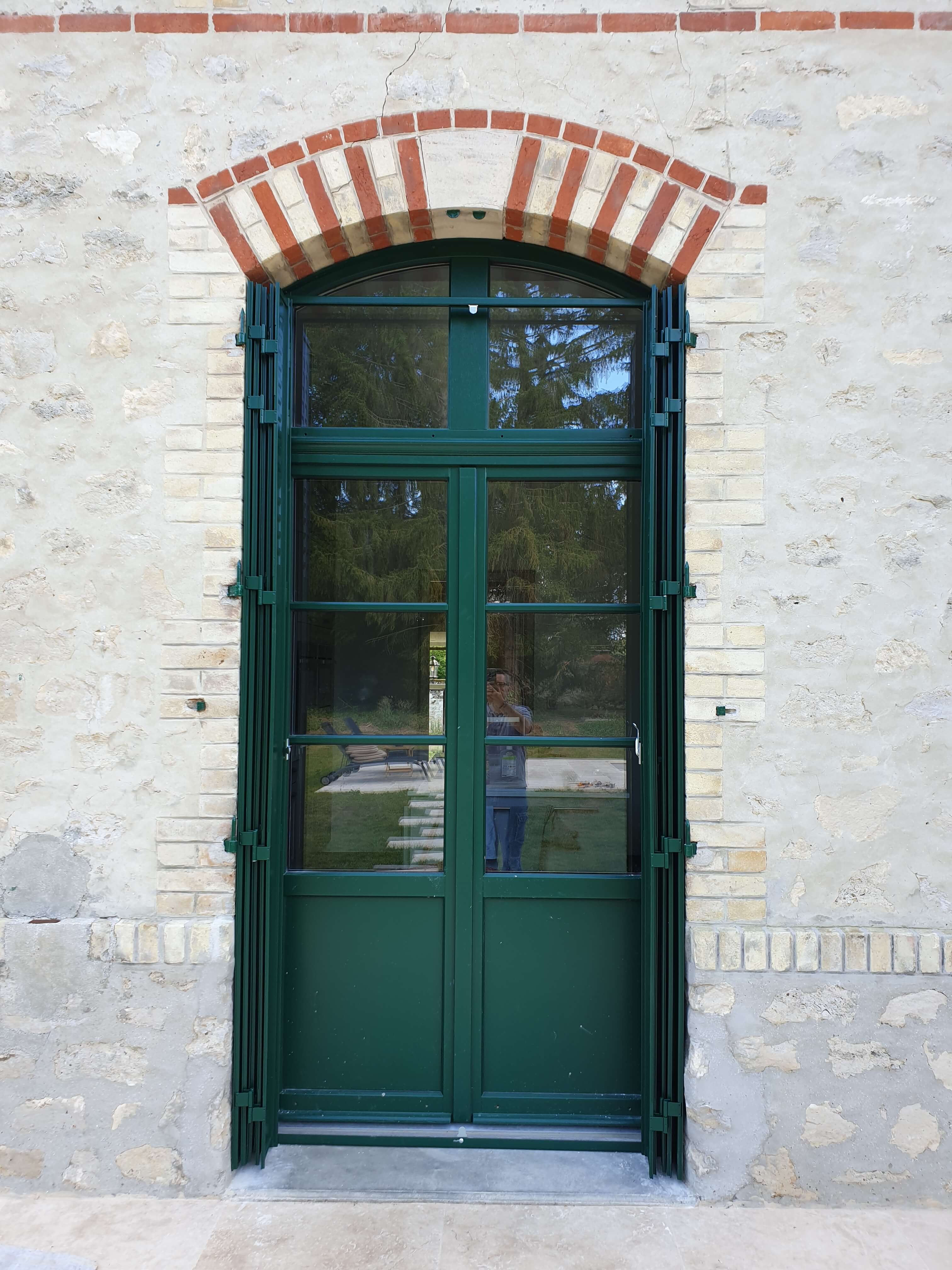 Porte d'entrée bois cintrée sur mur en pierre